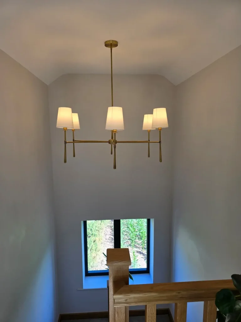 Chandelier installation above a stairwell